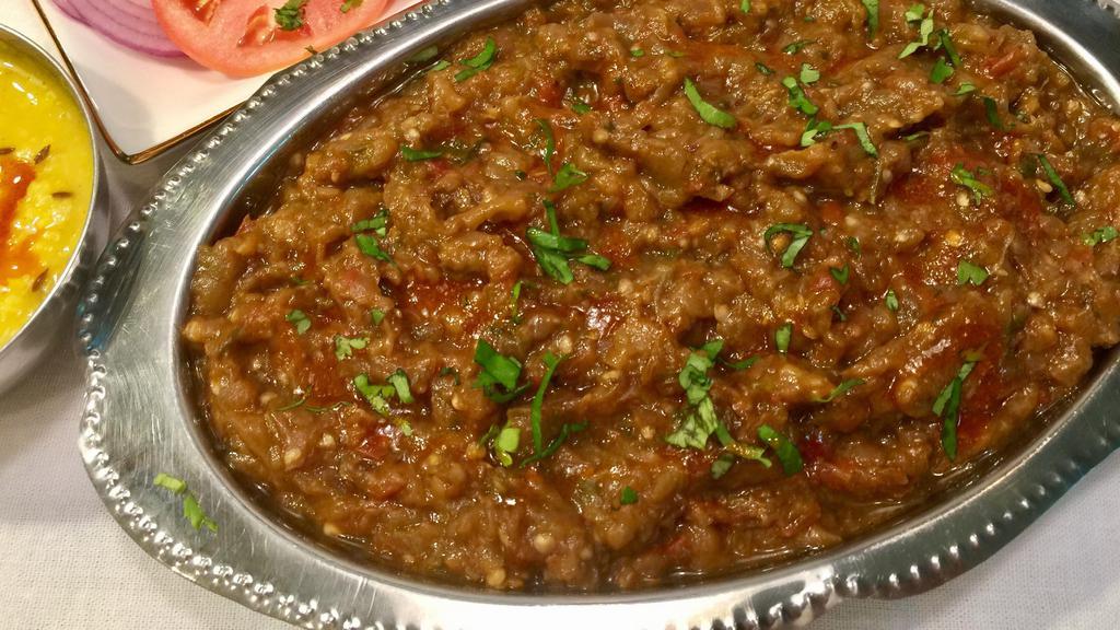 Baingan Bharta · Baked eggplant puree cooked with tomato, onion, and herbs. Served with basmati rice on side.