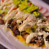 Huarache · Handmade Tortilla Stuffed with Beans Topped With Meat, Lettuce,& Tomatoes Drizzled with Sour...