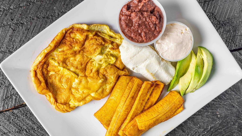 Huevos Con Tomate / Eggs With Tomato · Frijoles, queso, crema, aguacate y plátano. / Beans, cheese, sour cream, avocado and plantain.