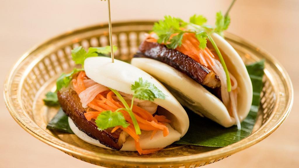 Pork Bun · Five spices and xo wine braised pork belly, pickled daikon and carrots, hoisin sauce and garnished with cilantro.