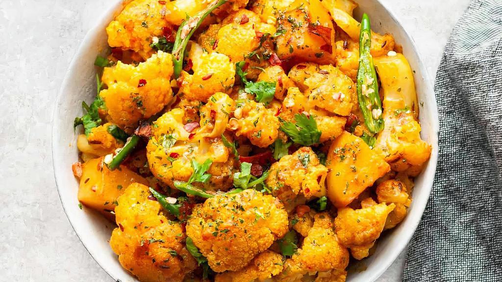 Aloo Gobi Masala · Freshly cut cauliflower, tomatoes and potatoes cooked to perfection with exotic Indian spices topped with fresh ginger.