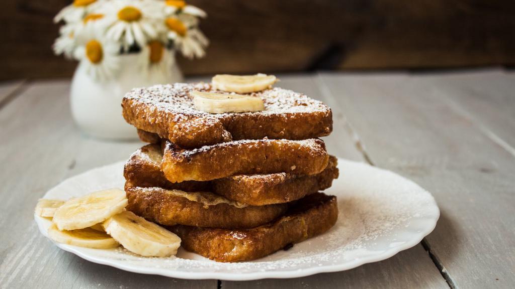 Banana French Toast · Thick slices of bread, soaked in a rich, eggy mixture and griddle to golden perfection. Topped with sweet banana slices and served with real butter and maple syrup.