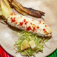 Elote · Mexican street corn; grilled corn on the cob with pesto & cotija cheese or Mexican style wit...