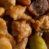 Chicken Scarpariello · Pieces of chicken in a brown sauce with garlic, pepperoncini peppers, sausage, and potatoes.