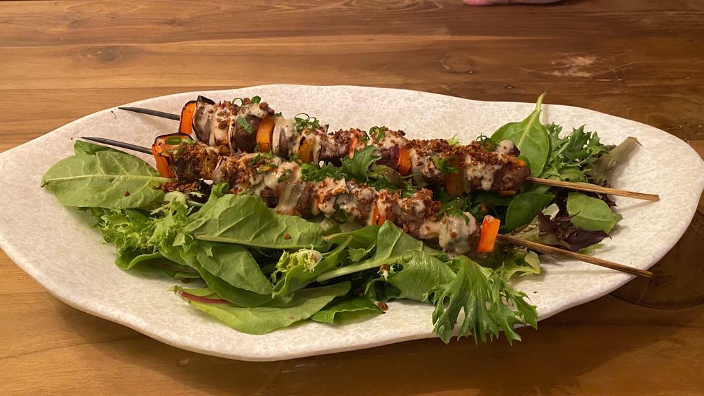 Thai Beef Brochette · Skewered Ribeye with Red Bell Peppers and White Onions. Topped with a Creamy Peanut Sauce and Grilled with Salt and Pepper.