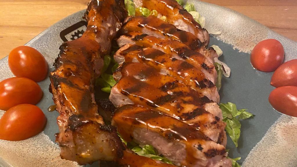 Vietnamese Pork Chop · Grilled Pork Chops Marinated in a House Special Sauce. Served with Asian BBQ Sauce on a Bed of Greens and Garnished with Cherry Tomatoes.