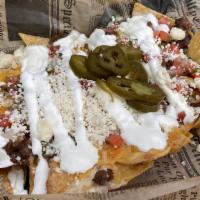 Loaded Nachos · Topped with Jack and Cheddar cheese, sour cream, queso fresco, pico de gallo and jalapeños.