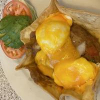 Huevos Rancheros · Refried beans in tortilla with poached eggs, cheddar cheese and sliced avocado.