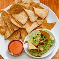 Guacamole · With pomegranate seeds and homemade corn chips.
