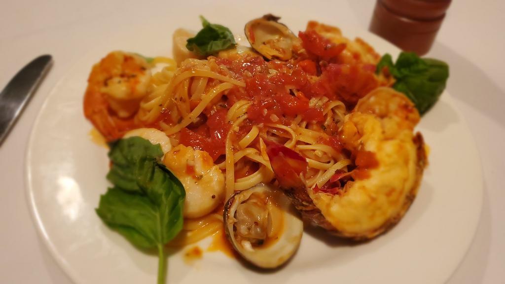 Seafood Fra Diavolo · Lobster tail, shrimp, scallops, and clams over pasta.