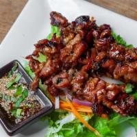 Moo Ping · Grilled marinated pork on skewers and served with Thai style spicy tamarind sauce.
