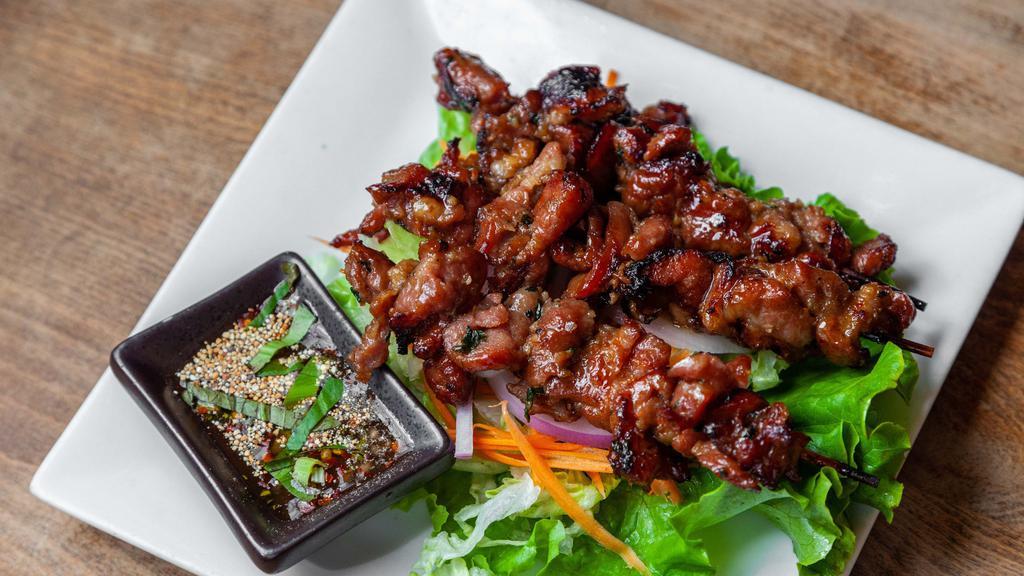 Moo Ping · Grilled marinated pork on skewers and served with Thai style spicy tamarind sauce.