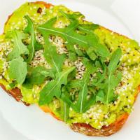 Avocado Toast · Topped with arugula, drizzled with olive oil, with a sprinkle of sesame seeds served on mult...