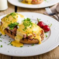 Eggs Benedict · Two fresh poached eggs, bacon, and hollandiase sauce sitting on a toasted English muffin.