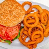 Cheese Burger Deluxe · with lettuce, tomato, onions, and a side of coleslaw With a sliced pickle and French fries.