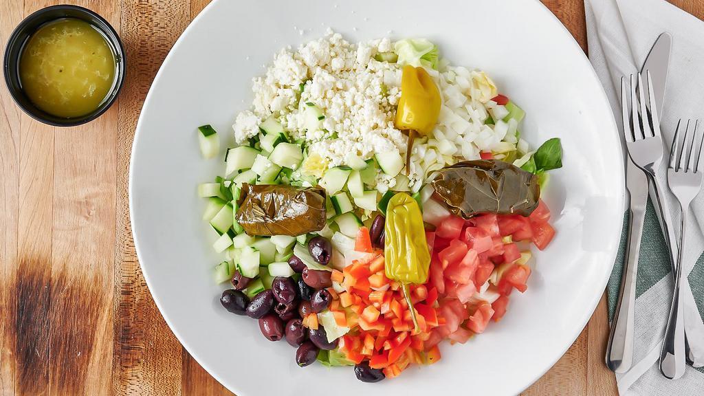 Greek Salad · Iceberg lettuce, tomatoes, cucumbers, peppers, feta cheese greek olives, onions, stuffed grape leaves, pepperoncini.