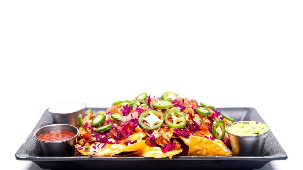 Tapchos · Fresh cut house chips smothered with grilled bbq chicken. Jalapenos, shaved lettuce. Pico de gallo and cheddar cheese topped with red cabbage and served with salsa, sour cream and guacamole.
