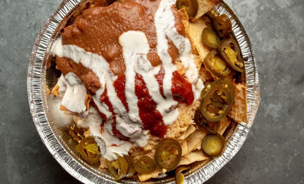 Vegan Nachos Supreme · Corn chips baked with vegan cheese and topped with pinto mash and salsa.