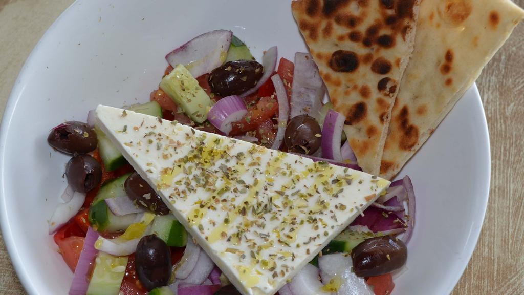 Horiatiki Salad · Tomatoes, cucumbers, red pepper, red onion, olives, slab feta, extra virgin olive oil, and a hint of oregano.