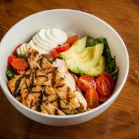 The California Cobb Salad · Grilled sliced chicken, Baby kale, Avocado, tomatoes, olives, applewood smoked bacon, hardbo...