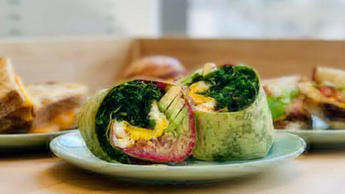 Quinoa Power Wrap · Two eggs, beet almond hummus, kale, quinoa, avocado, pickled red onions, drizzled with kale basil pesto on a spinach wrap.