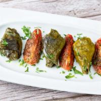 Fire Roasted Halumi · Halumi cheese, spiced and wrapped in grape leaves, with roasted tomato and fresh lemon