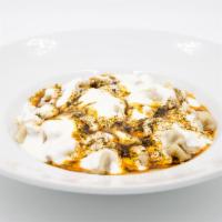 Turkish Ravioli (Manti) · Poached home-made beef dumplings, served with mint, garlic yogurt sauce.