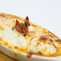 Moussaka · Eggplant layered with ground lamb and fresh tomatoes, topped with a light bechamel sauce and...