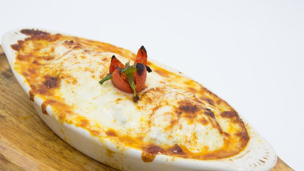 Moussaka · Eggplant layered with ground lamb and fresh tomatoes, topped with a light bechamel sauce and mozzarella cheese and baked to perfection. Served with jasmine rice.