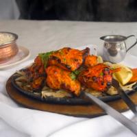 Tandoori Chicken Tika (Boneless Chicken Cubes) · Marinated in masala yogurt sauce and roasted in the clay oven and serve in sizzling plate wi...