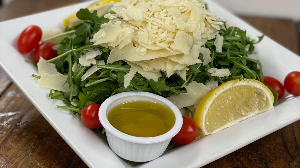 Arugula Salad With Shaved Parmesan · Arugula topped with Parmesan cheese, served with lemon and olive oil.