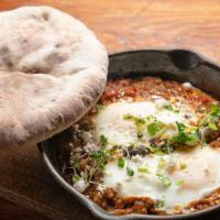 Chef Brekkie Pan · House-made moroccan merguez sausage with poached eggs and feta cheese, in a stew of tomatoes.