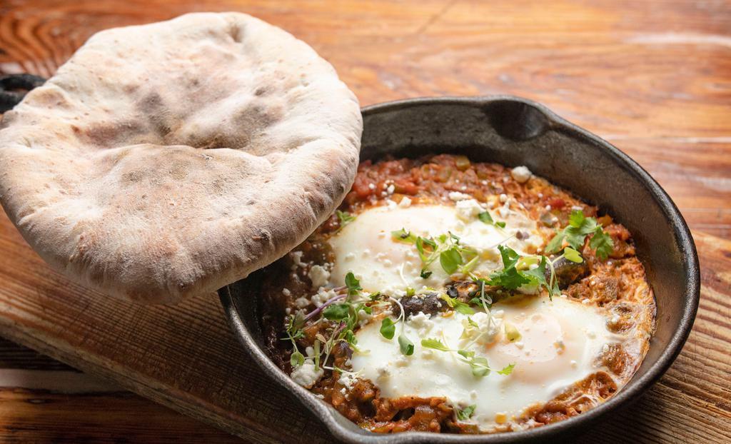 Chef Brekkie Pan · House-made moroccan merguez sausage with poached eggs and feta cheese, in a stew of tomatoes.