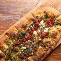 Spinach & Pesto Flatbread · Caramelized onions, sun-dried tomatoes and spinach topped with feta cheese and housemade pes...