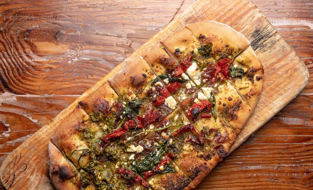 Spinach & Pesto Flatbread · Caramelized onions, sun-dried tomatoes and spinach topped with feta cheese and housemade pesto sauce.
