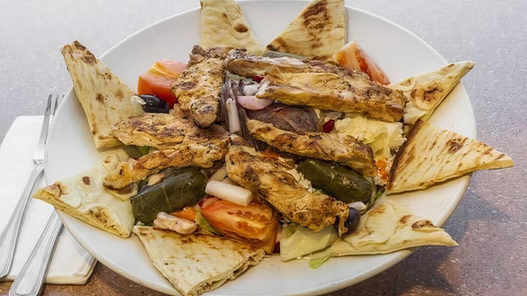 Greek Salad · With onions, fresh garden vegetables, olives, feta cheese,stuffed grape leaves, anchovies & our special house dressing,served with sliced pita bread.