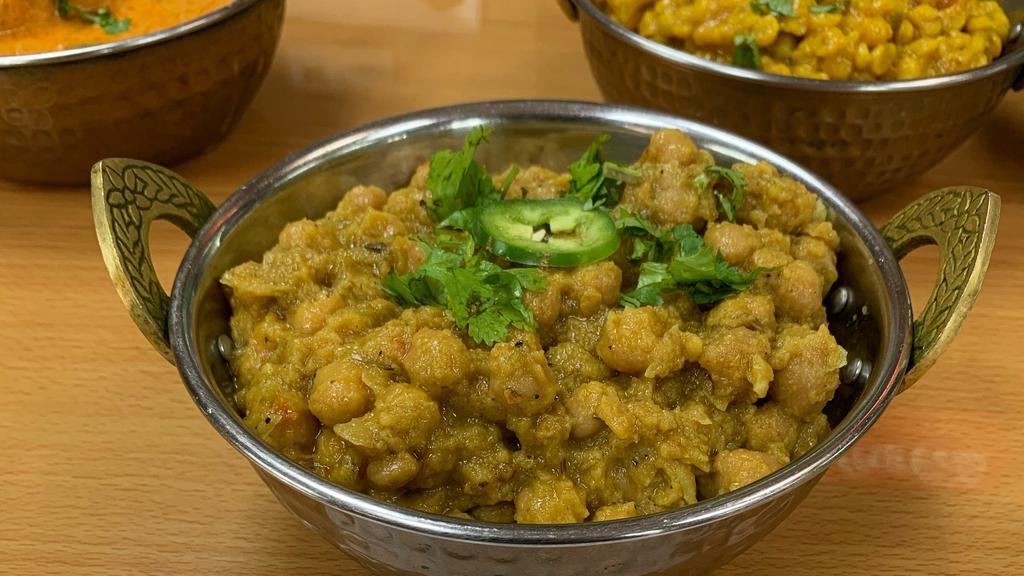 Chana Masala · Chickpeas boiled then cooked with chopped onion, chopped tomatoes, turmeric powder, cumin and coriander seeds with curry leaves.