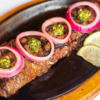 Churrasco · Sizzling grilled skirt steak, marinated with fresh herbs and spices, accompanied by chimichu...