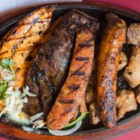 Parillada · Combination of sirloin steak, mexican chorizo, pork chop and grilled chicken.