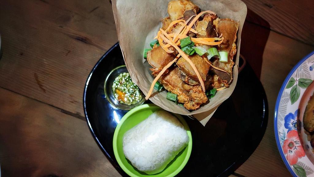 Jurassic Pork · fried flavorful pork belly with a side of crushed garlic spicy lime juice dipping sauce & a sticky rice
