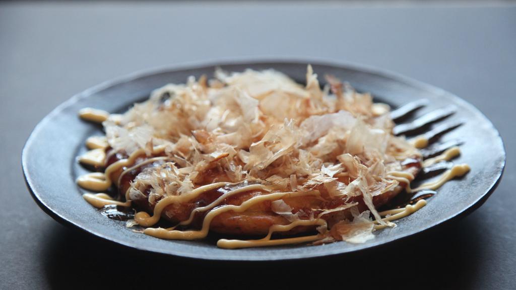 Okonomiyaki · Japanese style pancake with cabbage, onion, shrimp and squid. Topped with okonomiyaki sauce, mayonnaise and dried shaved bonito.