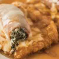Chicken Fiorentina · topped with prosciutto, spinach, and mozzarella in a light brown sauce with onion.