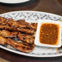 Moo Ping (Grilled) · Marinated pork seasoned with Thai herbs, garlic, and honey. Served with chili tamarind sauce.