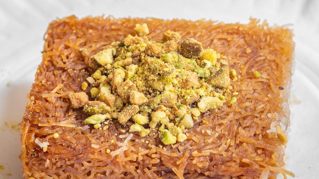 Kunafa · Shredded phyllo dough mixed with butter and filled with a mixture of ground walnuts, hazelnuts and soaked with syrup.