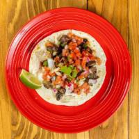 Carne Asada · Grass fed sliced Angus Steak, Guacamole,Cilantro,White Onion, Salsa Macha on a flour tortilla