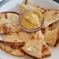 Pita Chips · Crisp baked pita triangles, virgin olive oil, and Parmesan cheese. Served with hummus.