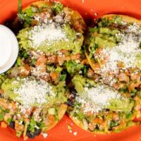 Avocado Tostada · Gluten free. Toasted corn tortillas topped with guacamole, pico de gallo, shredded lettuce, ...