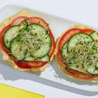 Hummus Bagel · A toasted bagel topped with hummus, refreshing cucumber and tomato slices, and crunchy bean ...