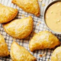 American Cheeseburger Empanadas · Seasoned ground beef, bacon, and American cheese. Grande empanadas, rice, and beans.