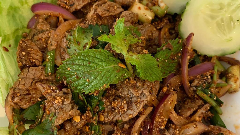 Nua Nam Tok · Sliced beef mixed with red onion, lemongrass, lime, chili powder, rice powder, cilantro, and scallion.